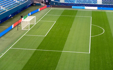 Fototapeta premium Soccer. Empty football field before the match. Green artificial turf surface and white field lines in a football or soccer playing field. 