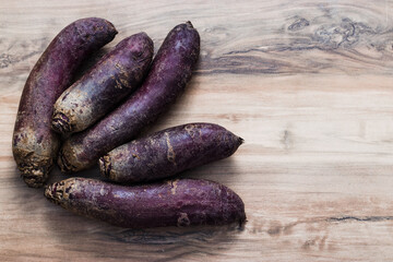 a lot of long red beetroots on a rustic wooden background, top view