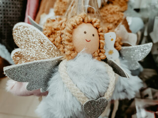 Christmas angel-toy hanging on the counter in the store. Buying Christmas toys.