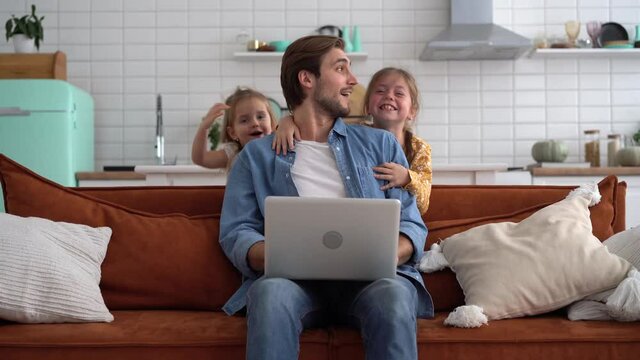 Caucasian male working from home with children, checking documents