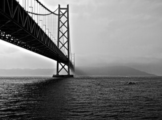 Fototapeta premium large bridge across the bay leading into the fog in monochrome