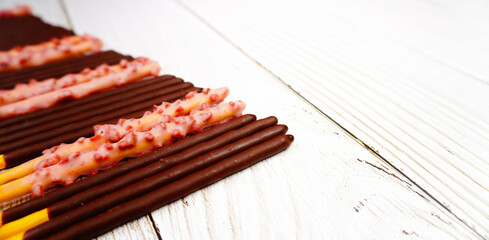 Close up of Pepero chocolate sticks of various flavors on the white wooden table.Original, Strawberry Flavored, Crunchy. Assorted chocolate dipped biscuits sticks.