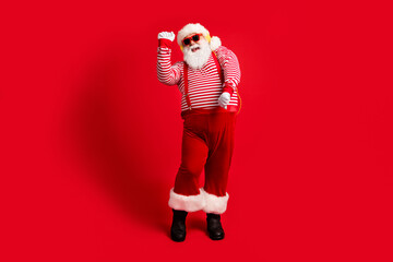 Full length body size view of his he handsome bearded fat overweight cheery glad childish Santa listening melody dancing amusement isolated bright vivid shine vibrant red color background