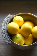 Fresh lemons in vintage silver bowl. Selective focus.