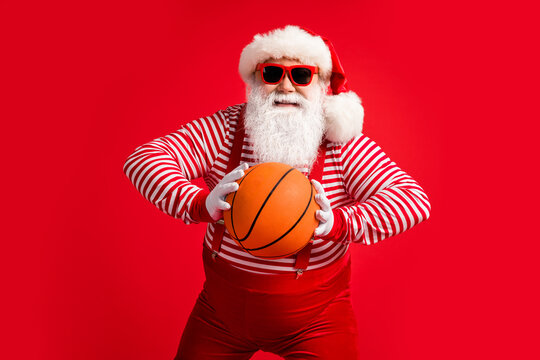 Portrait of his he nice handsome attractive cheerful cheery experienced fat overweight Santa grandfather playing basketball isolated over bright vivid shine vibrant red color background