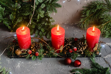 Christmas decoration composition with red candles, fir branches and balls. Top view