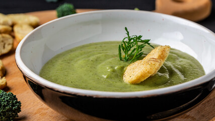 Fresh vegetable detox soup made of broccoli in dish on table, closeup. Clean eating, dieting, vegan, vegetarian, healthy food concept