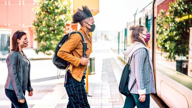 Young People Waiting In Line Practising Social Distancing At Bus City Station - New Normal Transport Concept With People Wearing Face Mask On Queue - Bright Backlight Filter