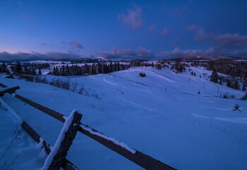 Night countryside hills, groves and farmlands in winter remote alpine mountain village. Ukraine, Voronenko.