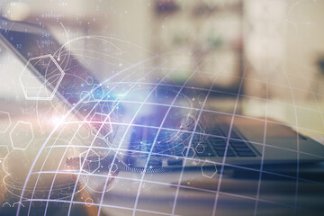 Double exposure of desktop with computer and world map hologram. International data network concept.