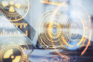 Computer on desktop in office with technology theme hologram. Double exposure. Tech concept.
