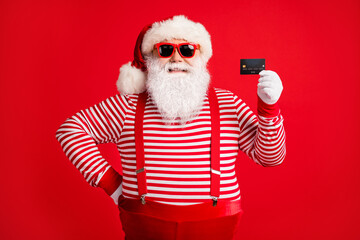 Portrait of his he nice handsome cheerful cheery Santa using holding in hand bank card bargain...