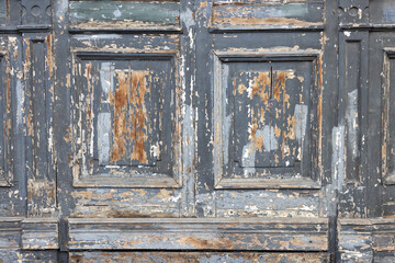 The surface of old wooden boards with peeling and weathered paint.