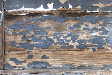 The surface of old wooden boards with peeling and weathered paint.