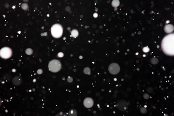 Freeze motion of white powder coming down, isolated on black, dark background. Abstract design of falling dust cloud. Particles cloud screen saver, wallpaper with copy space. Rain, snow fall concept