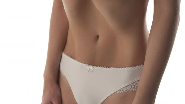 Close-up view of a womans belly. Nauli yoga vacuum exercise. Isolated on the white background.