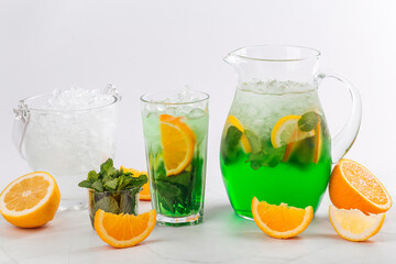 Side view on green lemonade in a jug and glass