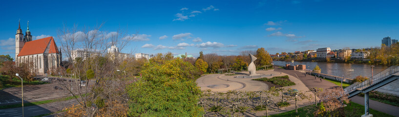 Panoramic view over historical downtown, old city in Magdeburg, Church of Saint Jochannis (Jochanniskirche) and Elbe river with bridge in golden Autumn colors, Germany, sunny day and blue sky