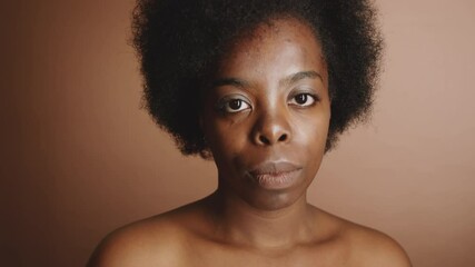 Chest up portrait of young beautiful topless woman of African ethnicity posing for camera in studio - Powered by Adobe