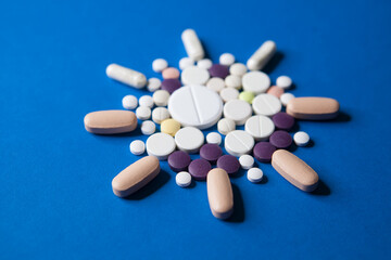 Covid-19 corona virus cure. Colorful medical pills on blue background for ncov-19 diseases treatment.