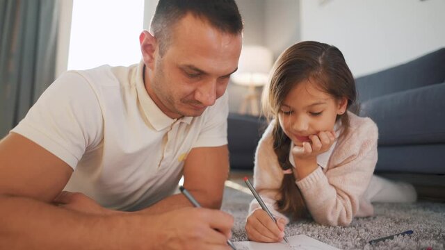 Father and daughter communicate, having fun and painting together. Concept of a happy family and quality leisure time