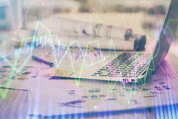 Stock market chart hologram drawn on personal computer background. Double exposure. Concept of investment.