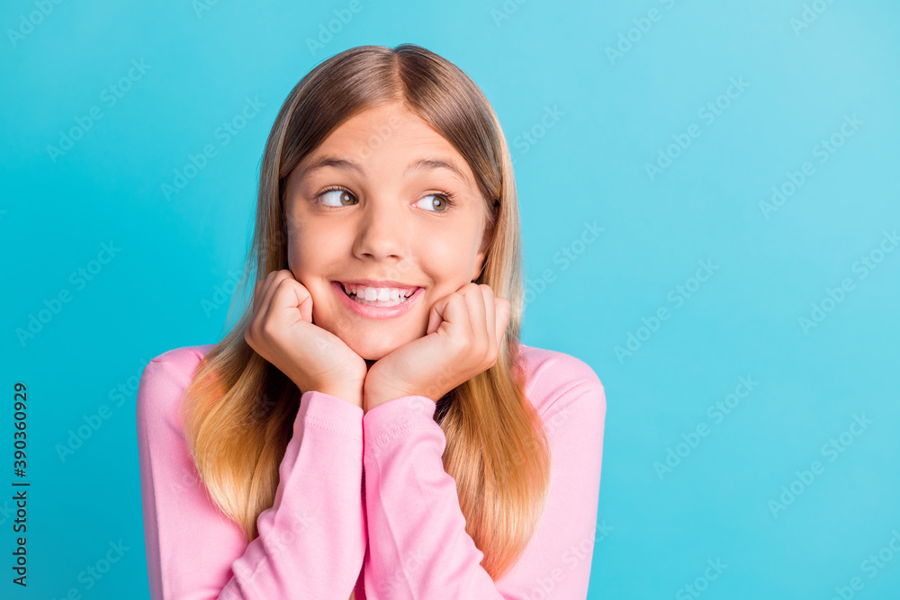 Sticker Photo portrait of dreamy schoolgirl with blonde hair smiling touching cheekbones with hands isolated on vibrant turquoise color background