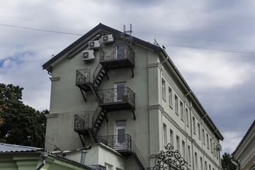 Metal staircase at the end of an office building. Photo for a site about architecture and restoration of old houses.