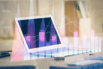 Stock market graph on background with desk and personal computer. Double exposure. Concept of financial analysis.