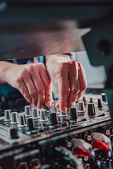 DJ Hands creating and regulating music on dj console mixer in concert nightclub stage