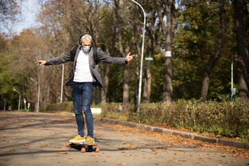 Fototapeta premium Happy man enjoying skateboarding outdoors during pandemic