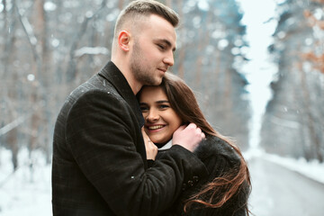 The concept of romance and love. Winter love story. smile, hugs and kiss of a couple in love.