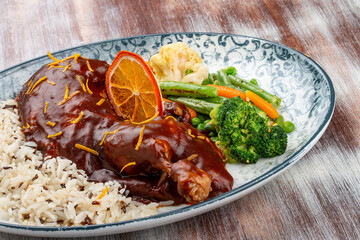 Duck in orange sauce with blanched vegetables and rice