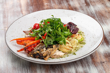 Grilled vegetables on a hummus cushion. Eggplant, pepper, tomato, zucchini, garlic.