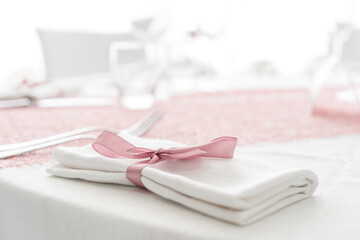 estive table. Plates and cutlery with pink napkin on a white background. Table setting.