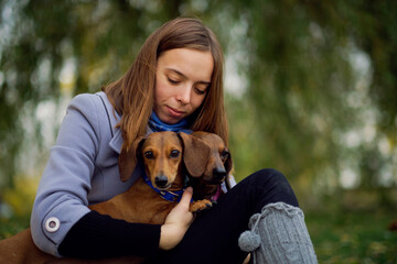 Smiling lady taking free time with her dog. Woman relaxing in the nature with her little dog....