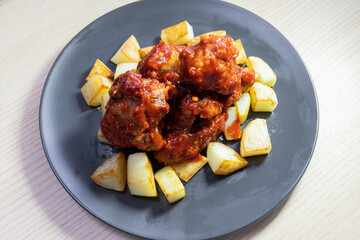Spicy fried chicken with baked potato.