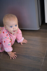 A baby crawls on the floor