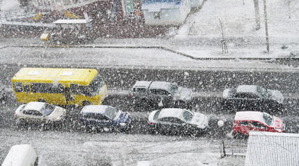 Snowing. Winter. City street with cars. - 390366554