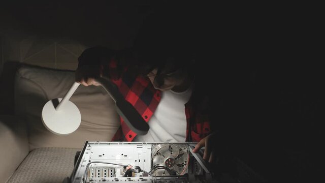 young person (teenager) is studying what is inside the computer.