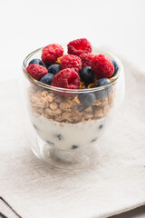 delicious granola with berries and yogurt in glass cup