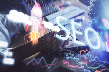 Multi exposure of woman's hands making notes with SEO icon. Concept of Search engine optimization