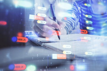 Double exposure of hands making notes with digital coding icons. Computer learning concept.
