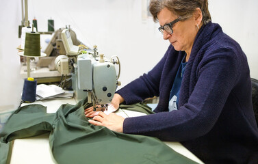 Tailor sews a clothes by machine.hand work concept related to professional knowledge and craftsmanship