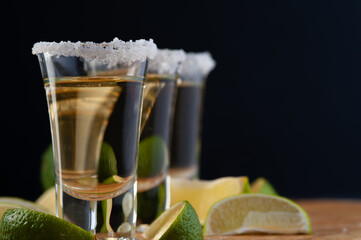 Shots of Mexican Gold Tequila with lime slices and salt.