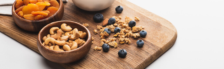 delicious granola with nuts,dried apricots and blueberry on white background, banner