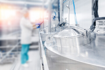 Dairy factory production, engineer operator check quality with computer tablet in milk tank