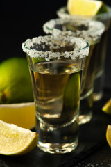 Shots of Mexican Gold Tequila with lime slices and salt.