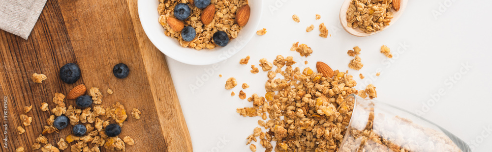 Wall mural top view of delicious granola with nuts, blueberry and dried apricots isolated on white, banner