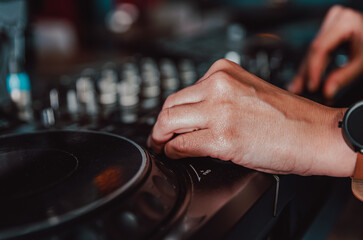 DJ Hands creating and regulating music on dj console mixer in concert nightclub stage